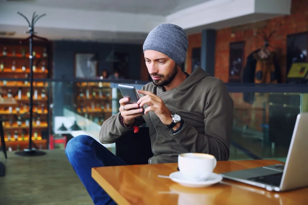 jeune homme hippie beau avec barbe assis dans un café